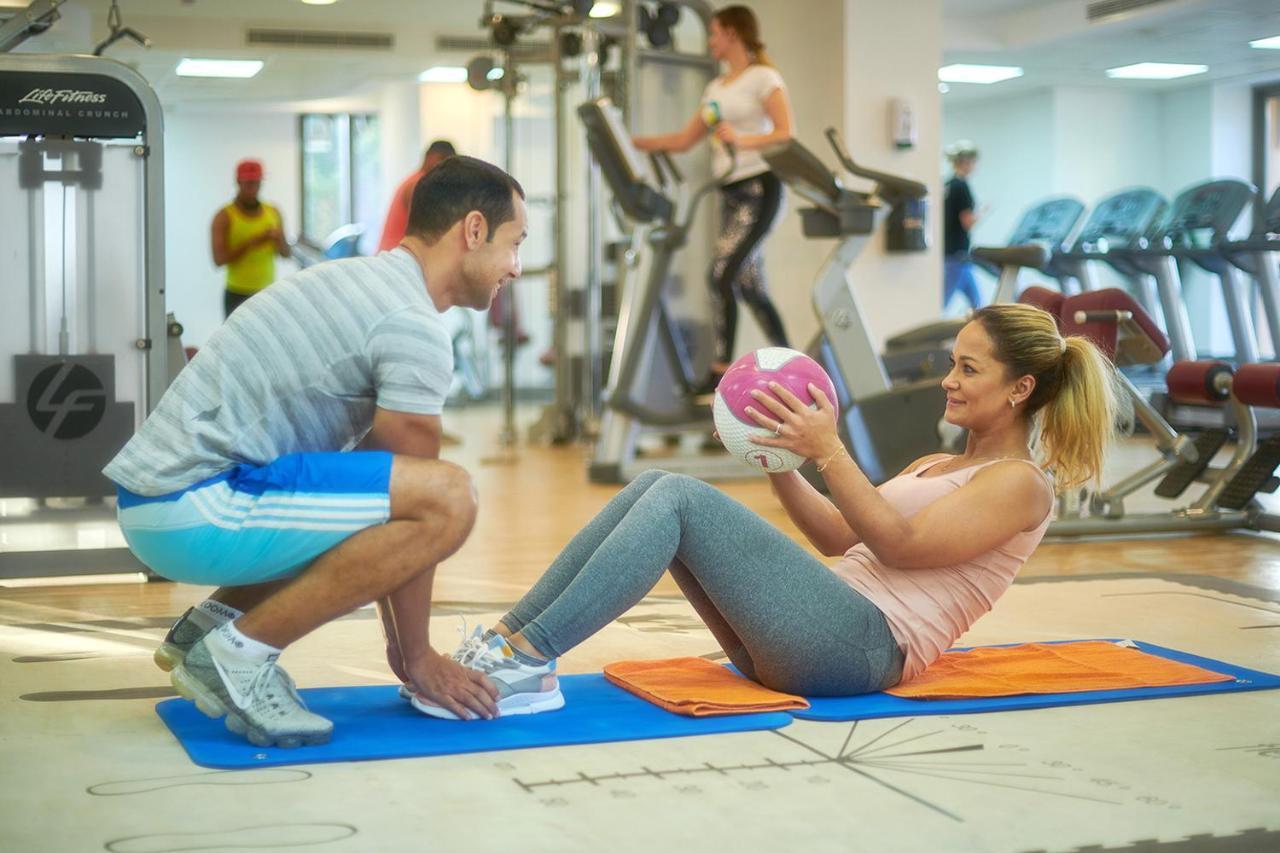 فندق باهي قصر عجمان المظهر الخارجي الصورة Personal trainer assisting a woman with sit-ups
